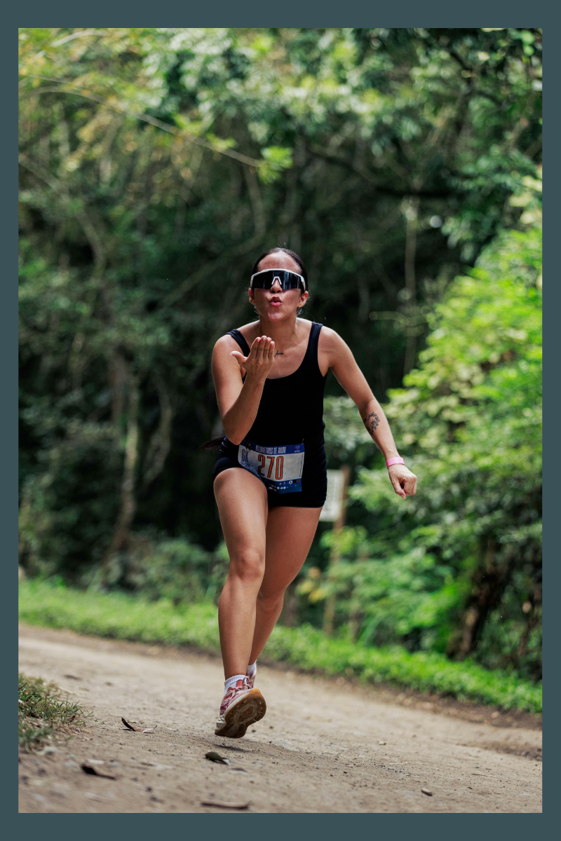 Woman runner racing on a trail path managing performance anxiety with focused breathing and mental training